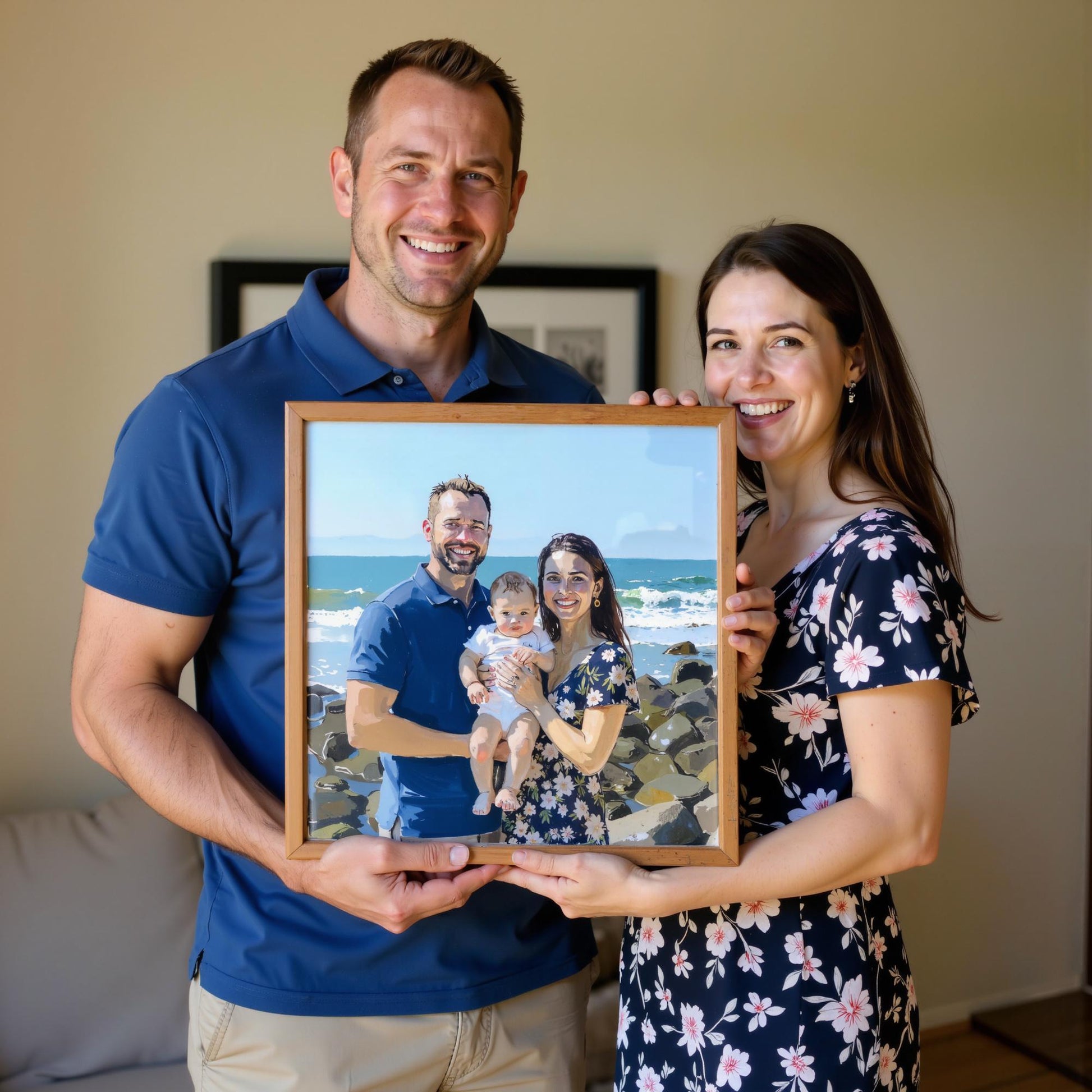 A couple holds a personalized family portrait on canvas, depicting them with their baby on a sunny beach. The framed artwork captures their love and joy with vibrant colors and expressive brushstrokes.