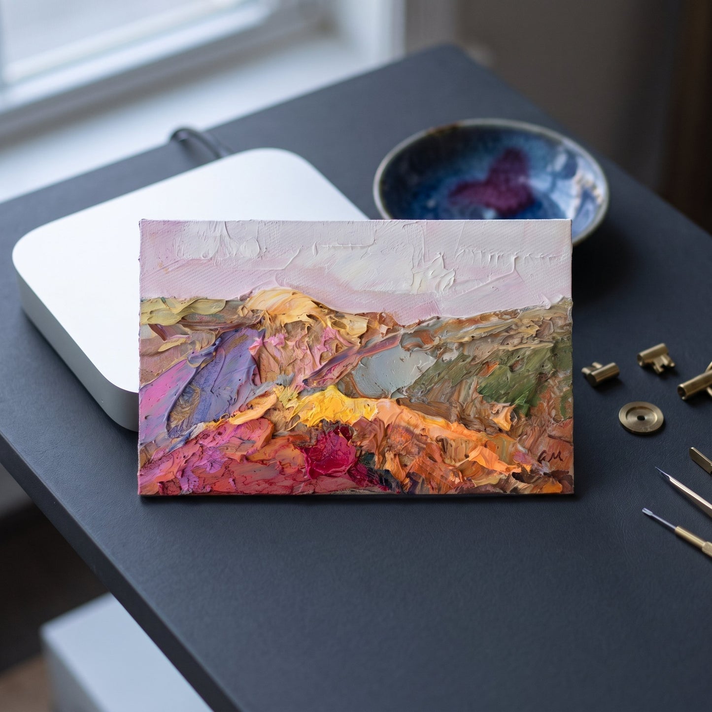Contemporary study — Expressive landscape painting adds vibrant color and texture to a minimalist workspace