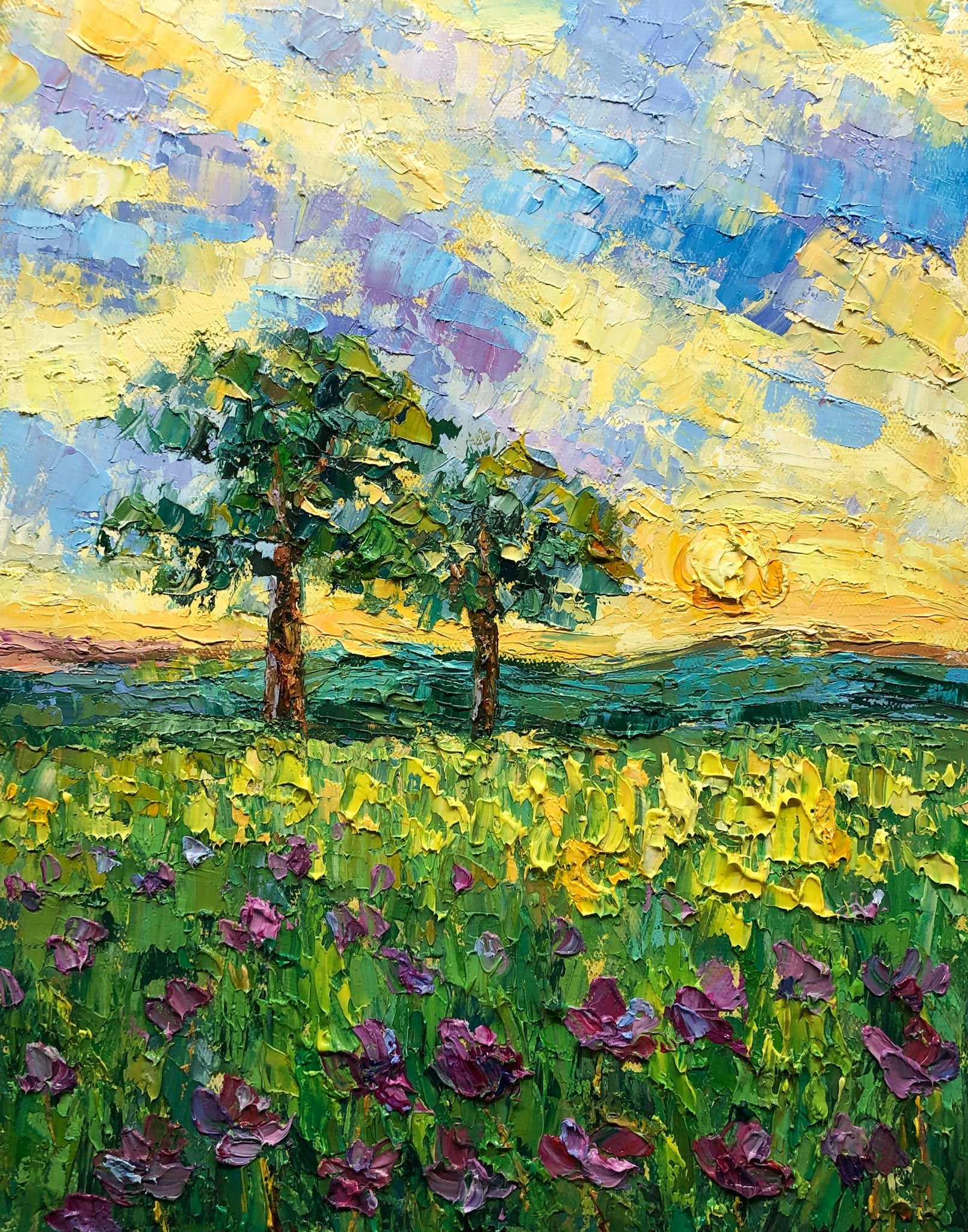 Hand-painted oil landscape of a vibrant spring meadow with purple flowers, two trees, and a golden sky; unframed canvas on neutral surface