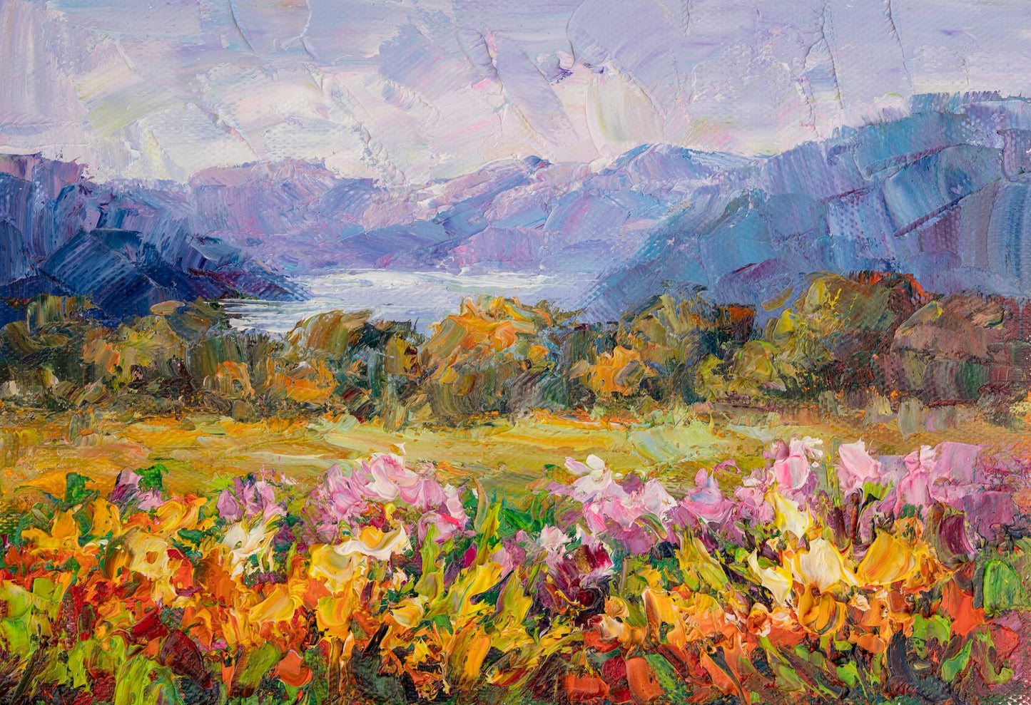 Hand-painted oil landscape of a vibrant mountain meadow with pink, yellow, and green flowers; distant blue mountains under soft purple sky; unframed canvas on neutral surface