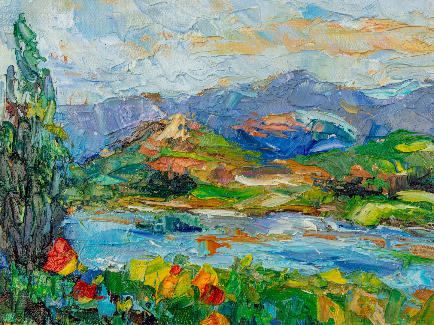 Heavy impasto oil painting of a mountain river scene with vibrant blues, greens, and yellows; unframed canvas on neutral surface