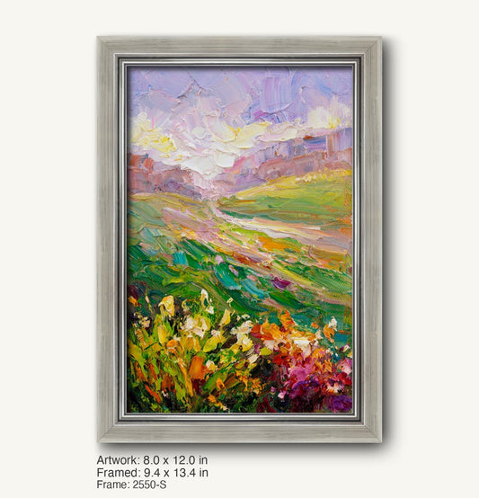 Vertical oil painting of a vibrant meadow landscape with floral foreground and rolling hills under a pastel sky, displayed in a modern slim silver frame with brushed texture and clean inner edge.