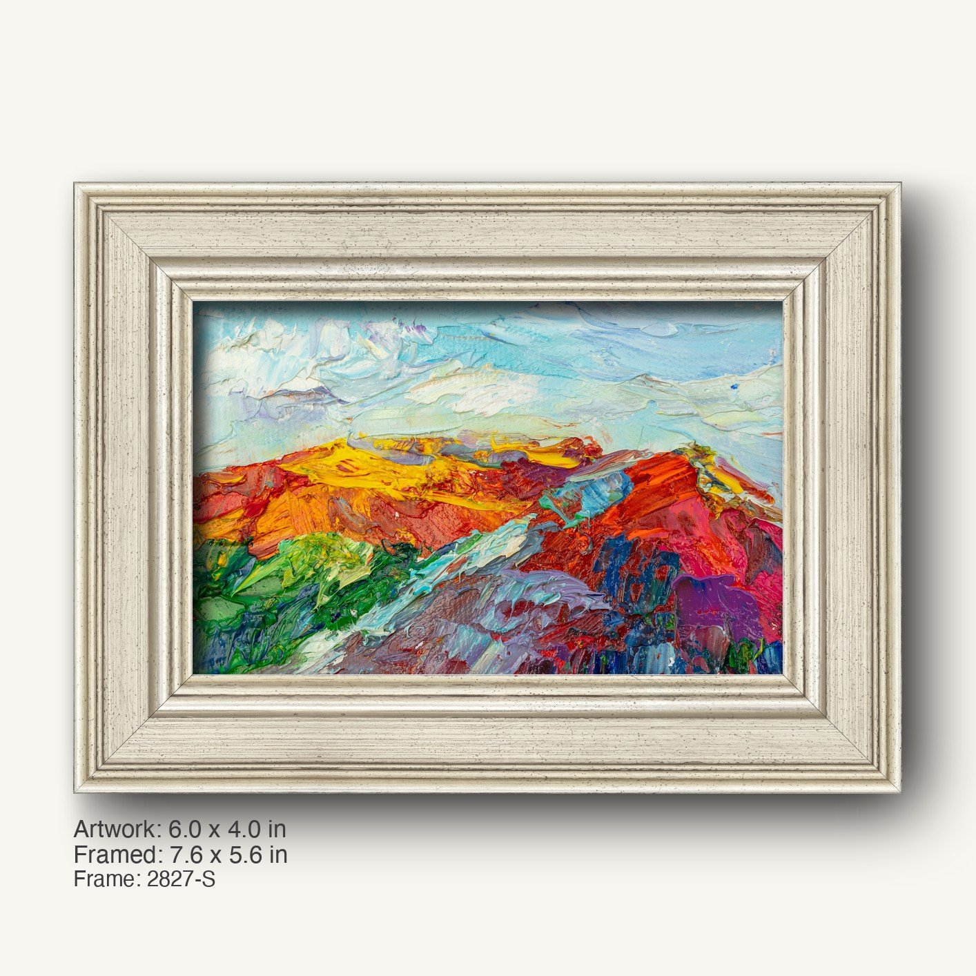 Abstract landscape oil painting in a white textured frame, featuring vibrant red, orange, yellow, green, and blue hues on canvas, displayed horizontally