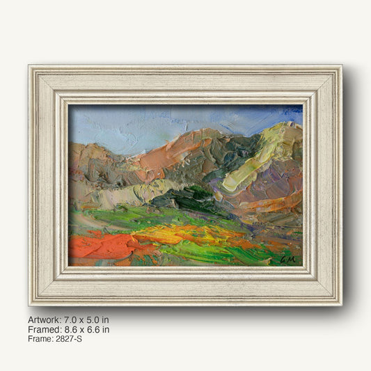 Vibrant desert canyon landscape painting in a white distressed wood frame, horizontal composition with textured oil brushwork and bold green, blue, and orange hues