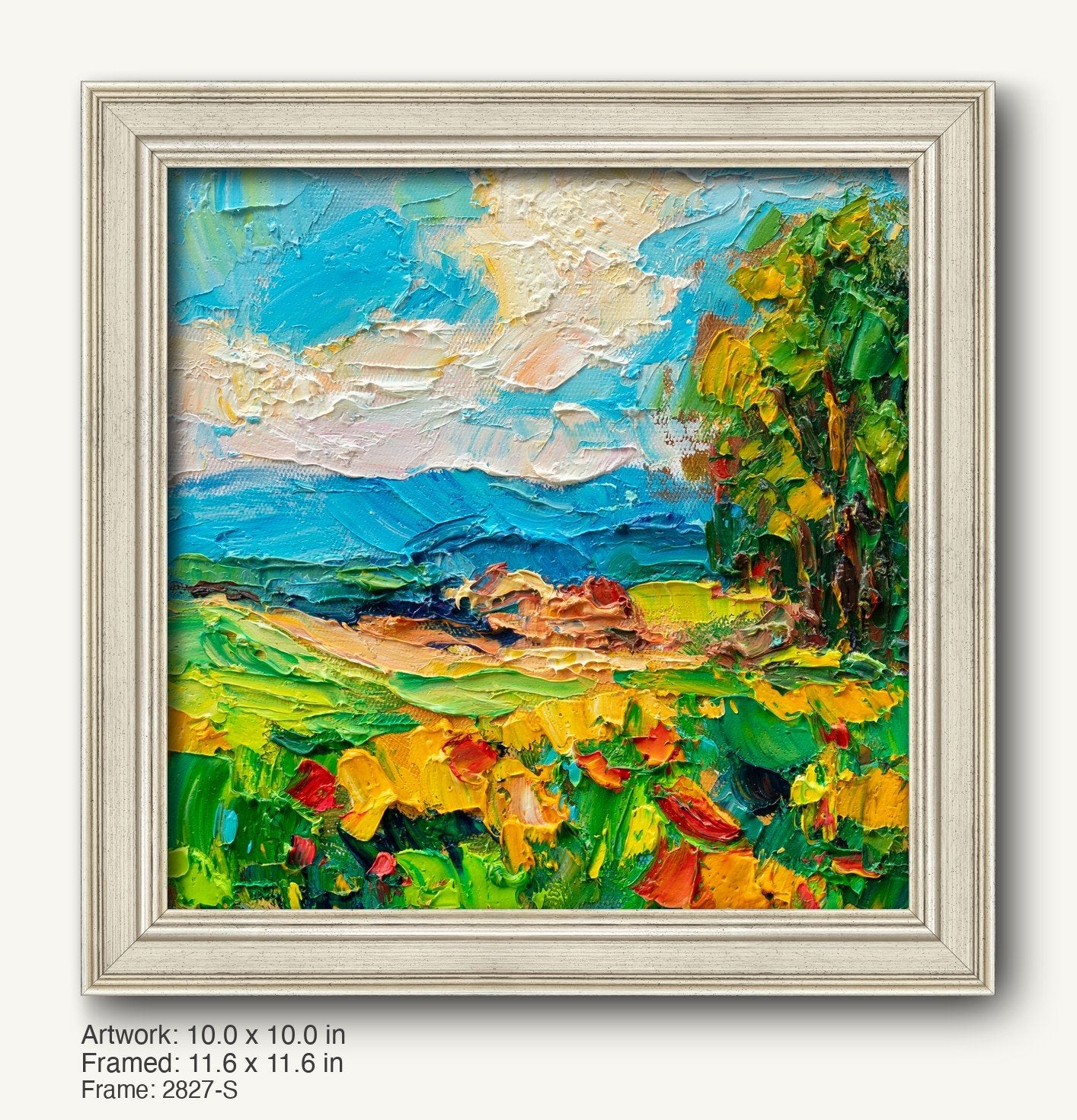 Vibrant coastal landscape oil painting in a white rustic frame, featuring textured brushstrokes of blue sky, green fields, and yellow flowers, displayed against a neutral background.