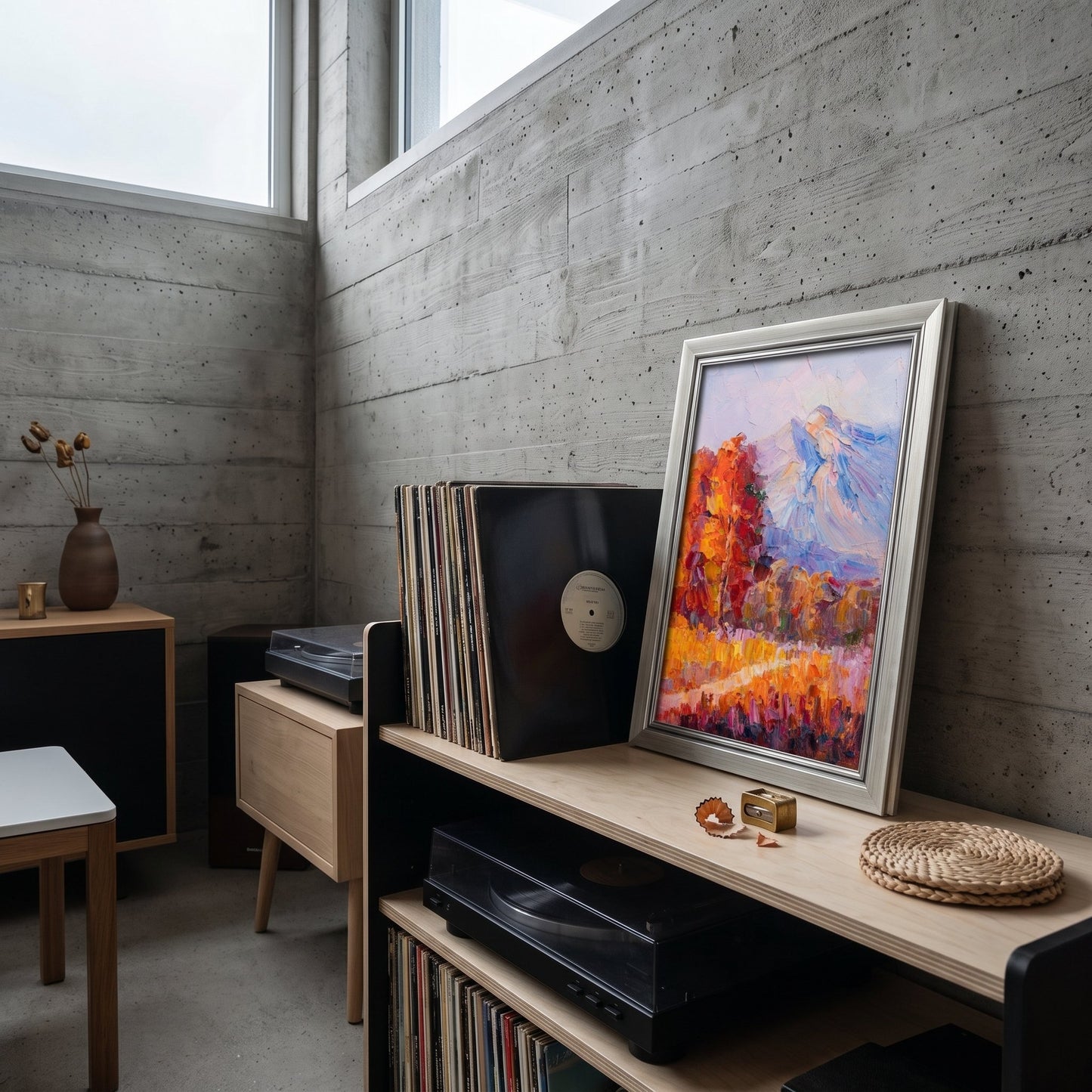 Industrial loft living room — vibrant Impressionist landscape adds warmth and color to minimalist concrete space