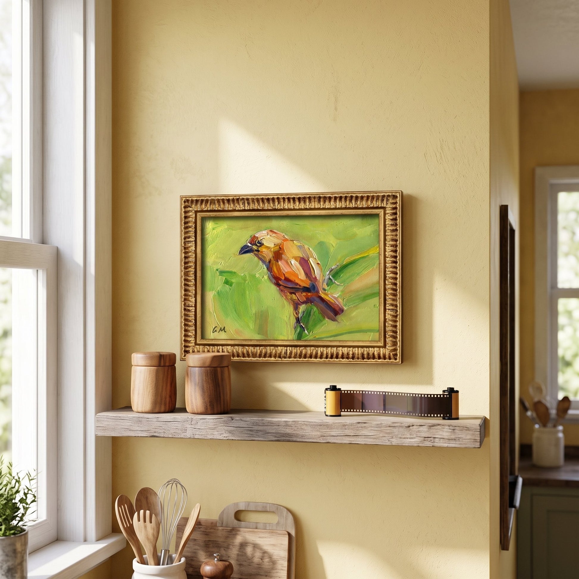 A golden-framed oil painting of a colorful bird perched on green leaves hangs above a rustic kitchen shelf, bathed in soft daylight.