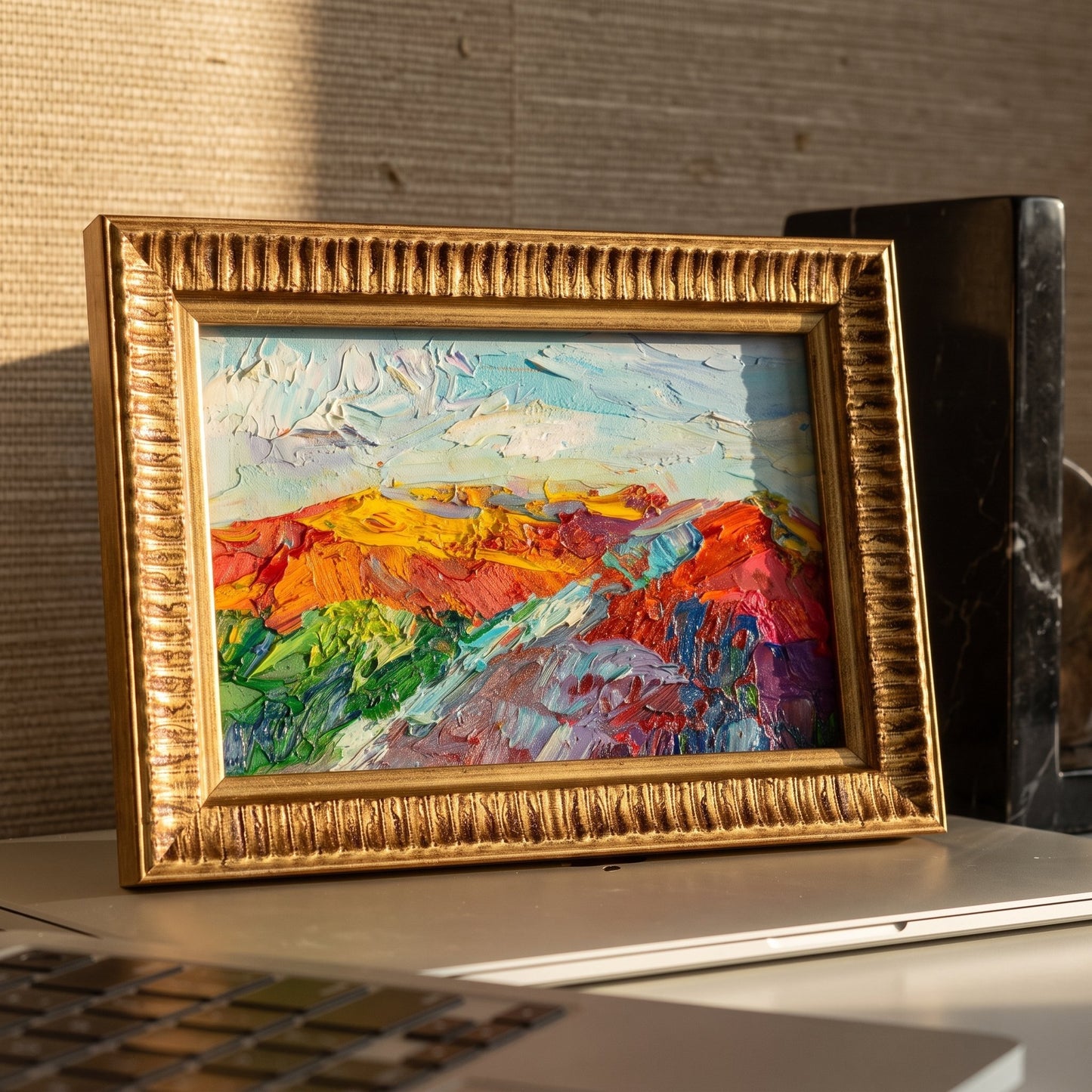 Modern home office — vibrant expressionist landscape painting adds color and energy to minimalist workspace