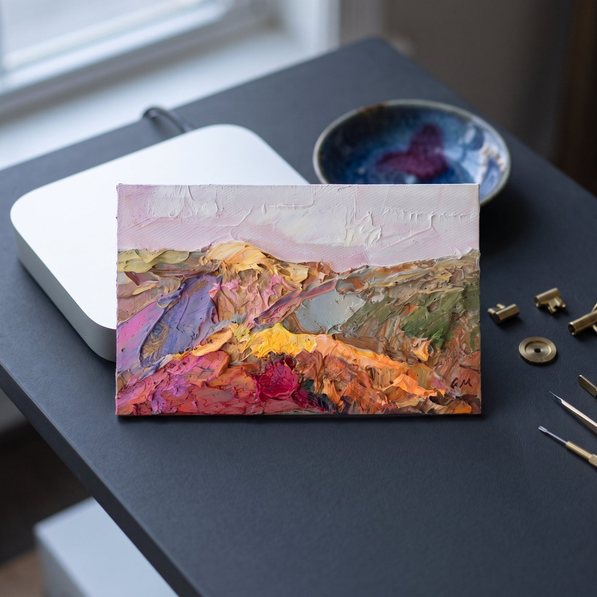 Contemporary study — Expressive landscape painting adds vibrant color and texture to a minimalist workspace