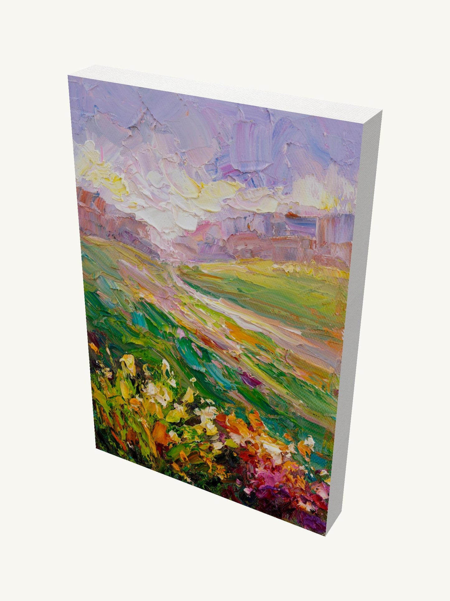Vertical oil painting on gallery-wrapped canvas depicting a vibrant meadow landscape with floral foreground, rolling hills, and soft sky; viewed at an angle showing depth and side edges