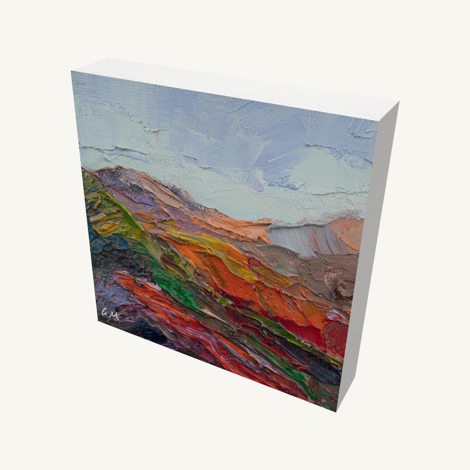 Vibrant impasto mountain landscape painting on gallery-wrapped canvas, viewed at an angle, showcasing thick oil texture and colorful abstract terrain with visible side edges and soft shadow
