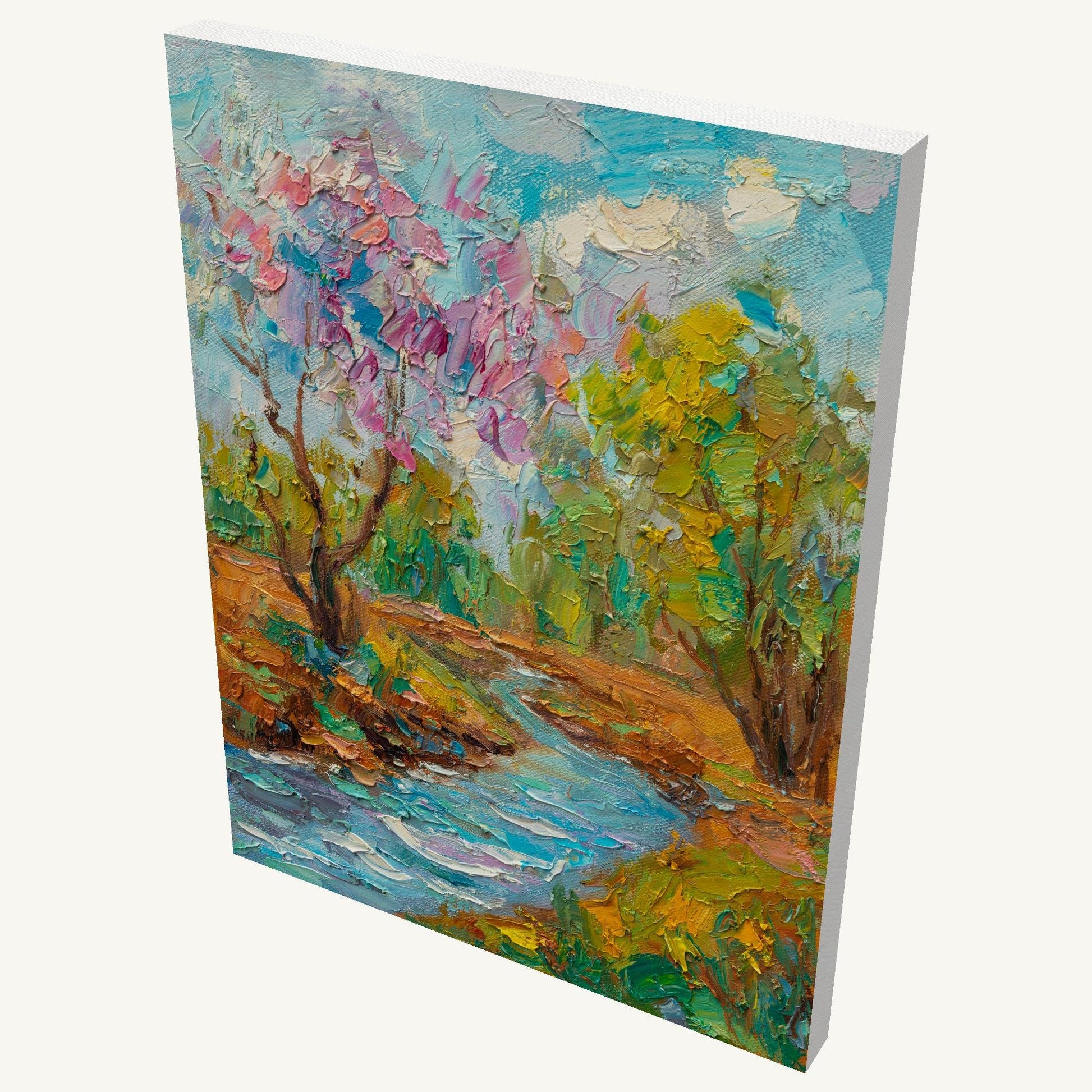 Vertical oil painting on gallery-wrapped canvas depicting a vibrant spring stream landscape with blooming pink trees, green foliage, and textured brushwork; viewed at an angle showing depth and side edges