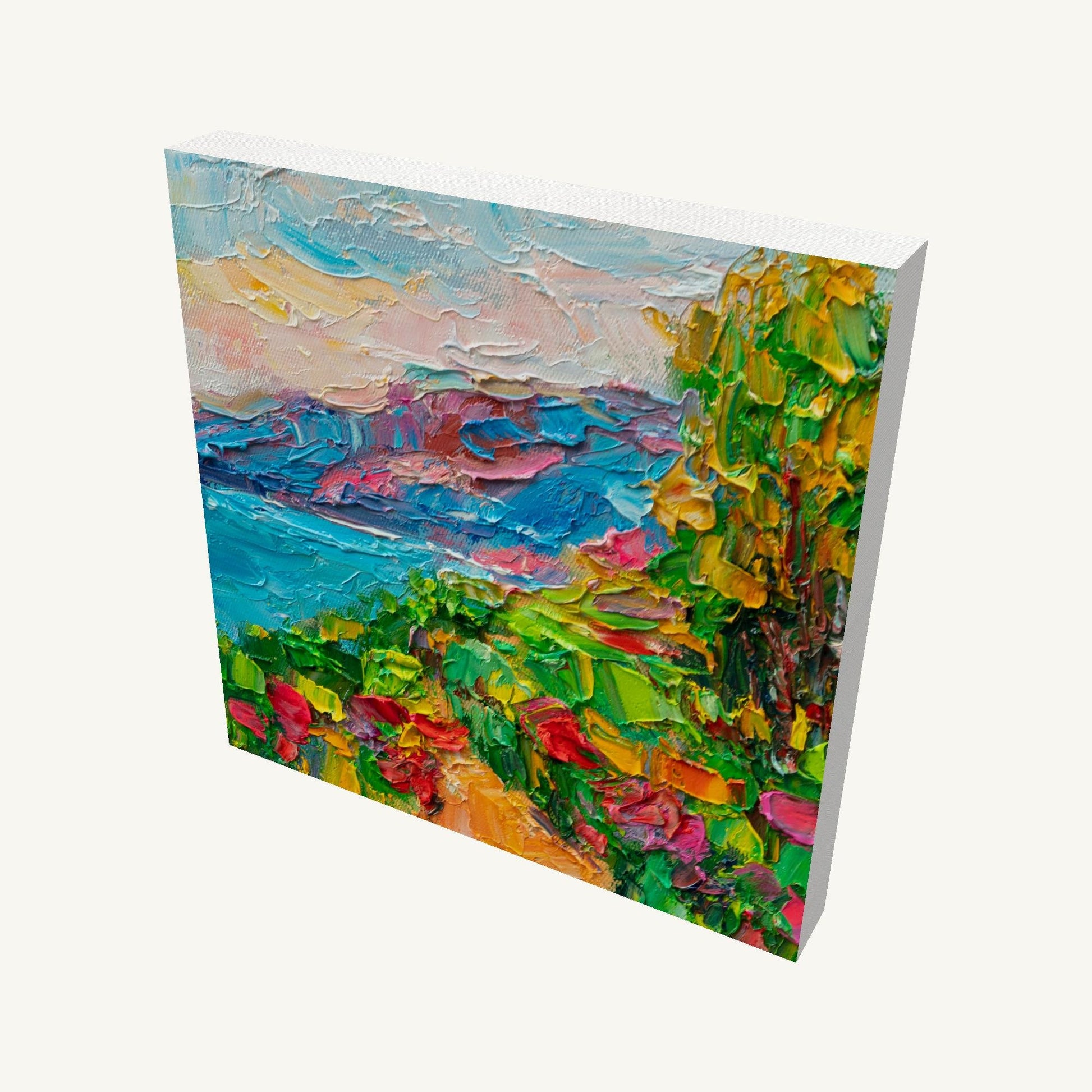 Vibrant coastal garden landscape painting on gallery-wrapped canvas, viewed at an angle, showcasing thick impasto texture and vivid colors with visible side edges and soft shadow